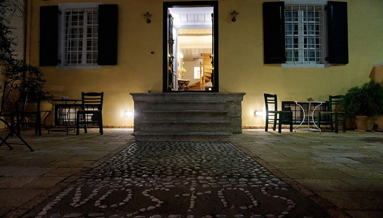 The courtyard entrance at night, with the hotel name laid in pebbles