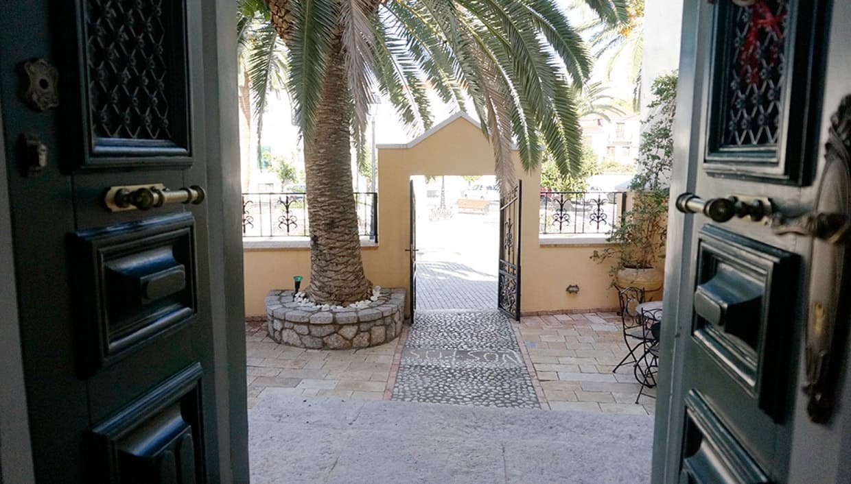 The open entrance doors looking out to the palm tree in the front yard