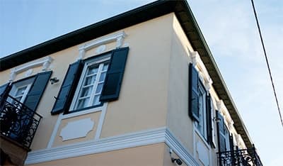 The corner of the mansion, with its shutters and iron balcony
